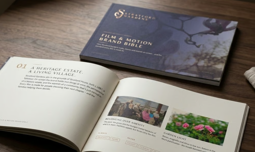 Open illustrated book and navy “FILM & MOTION BRAND BIBLE” on a wooden table.
