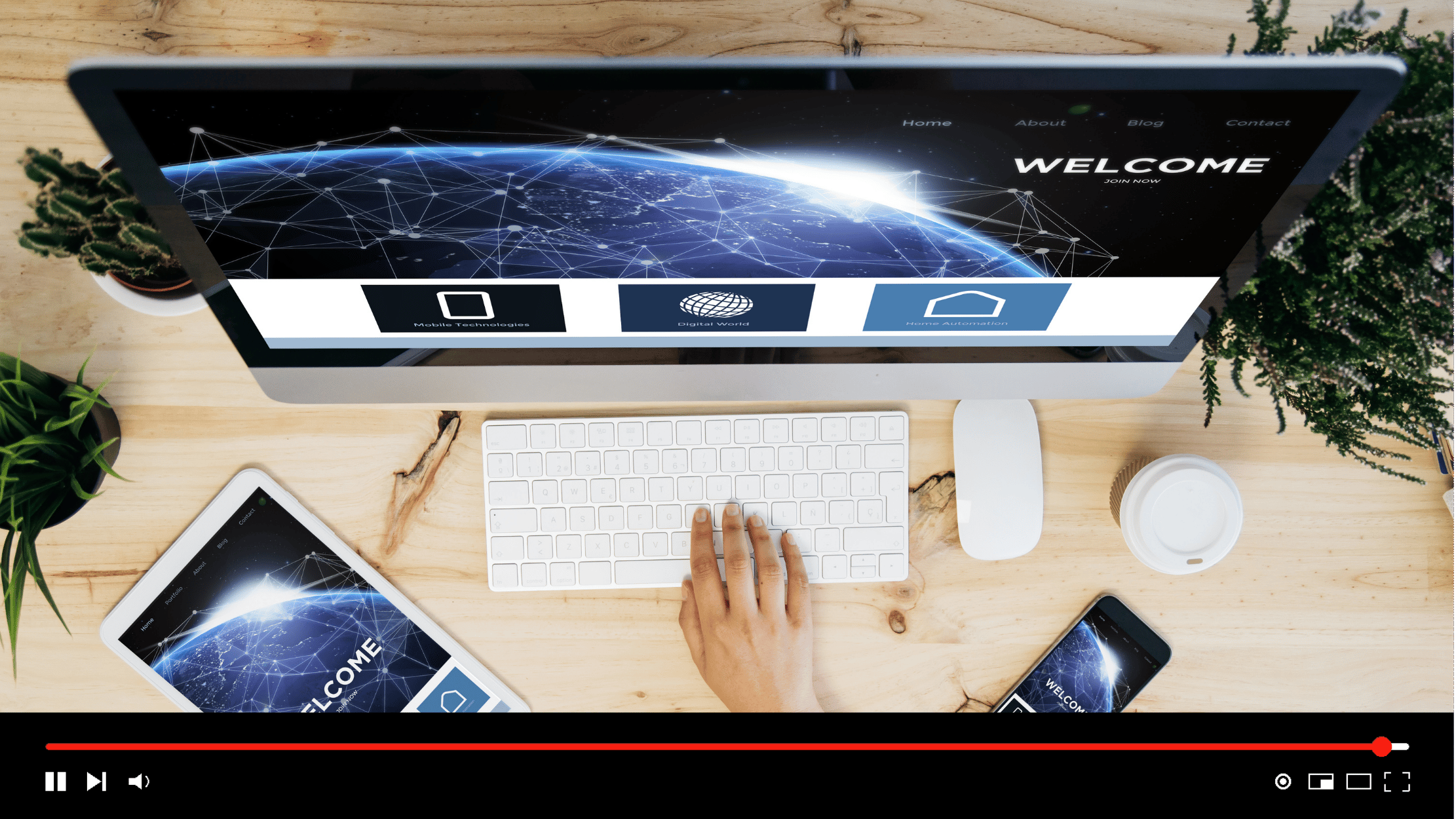 Desktop setup showing a networked-Earth welcome website on a monitor, tablet, and smartphone.